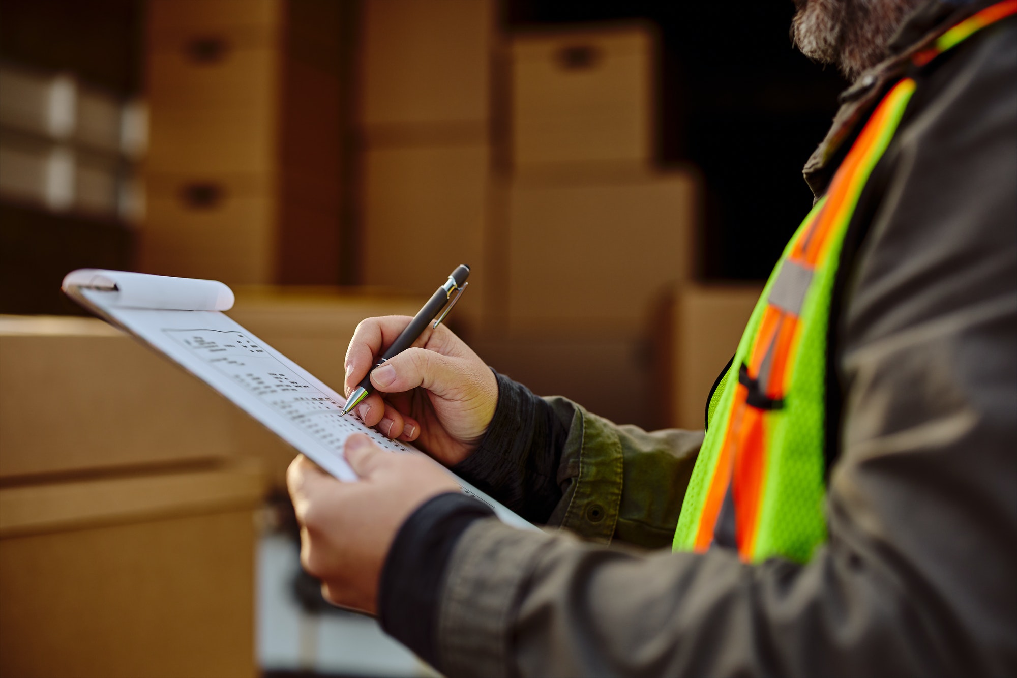 Close up of delivery man analyzing checklist before the shipment.